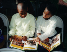 Two boys reading books together.